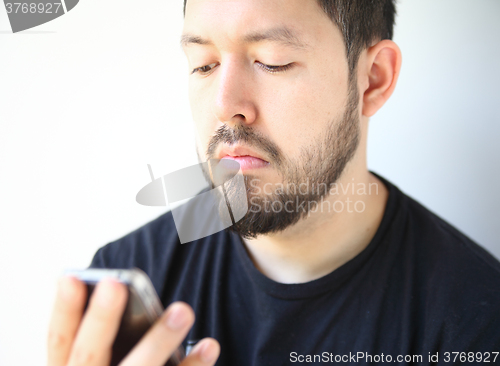 Image of Young man checks his phone