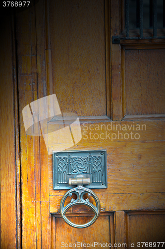 Image of handle in london antique brown door  rusty  brass nail and light