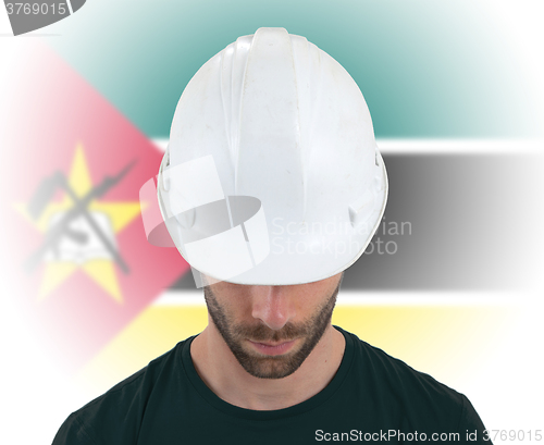 Image of Engineer with flag on background - Mozambique