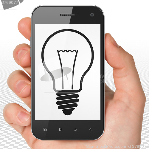 Image of Business concept: Hand Holding Smartphone with Light Bulb on display