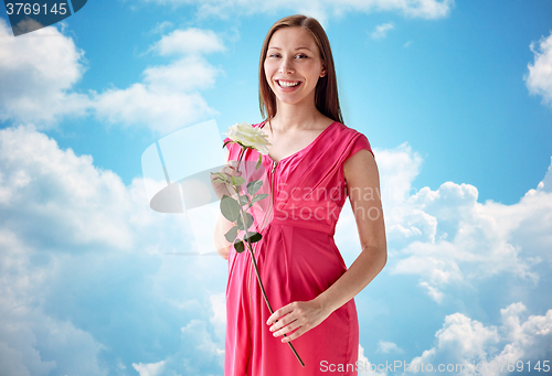 Image of happy pregnant woman with rose flower