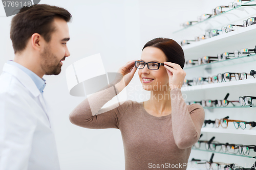 Image of woman choosing glasses at optics store