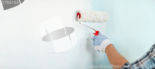 Image of close up of male in gloves painting wall