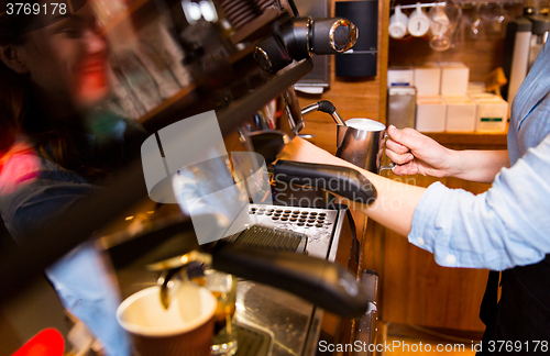 Image of close up of woman making coffee by machine at cafe