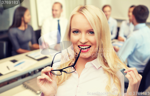 Image of smiling businesswoman or secretary in office