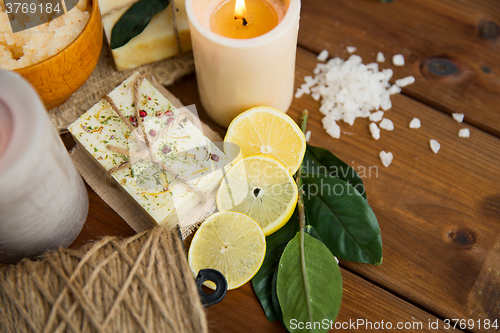 Image of close up of natural soap and candles on wood