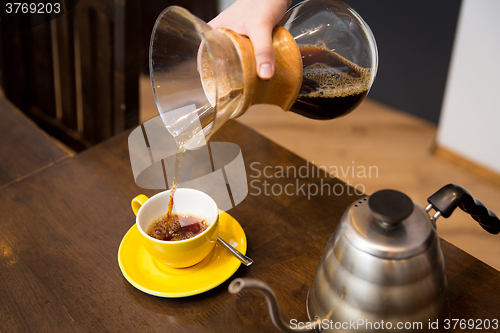 Image of close up of barista woman with coffeemaker and cup