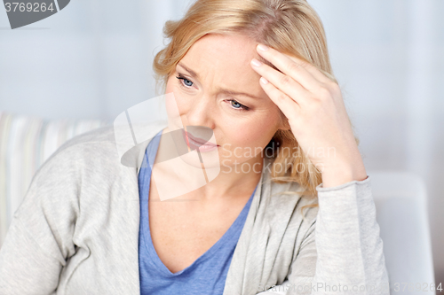 Image of woman suffering from headache at home