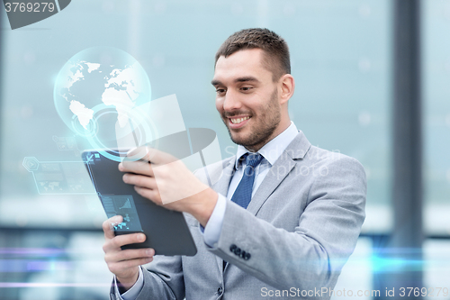 Image of smiling businessman with tablet pc outdoors