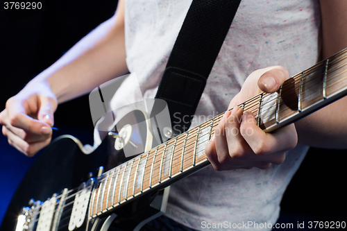 Image of musician playing electric guitar with mediator