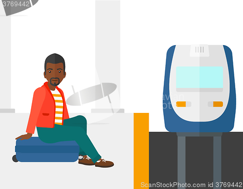 Image of Man sitting on railway platform.