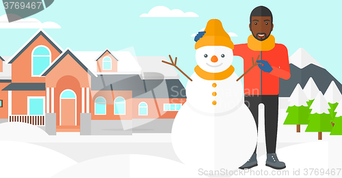 Image of Man posing near snowman.