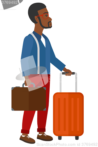 Image of Man with suitcase on wheels and briefcase.