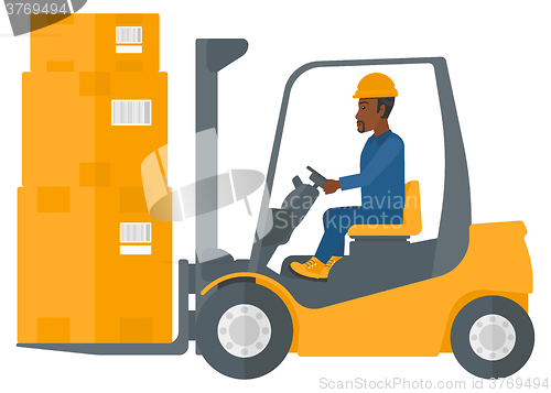 Image of Worker moving load by forklift truck.