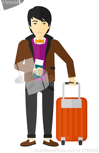 Image of Man standing with suitcase and holding ticket.