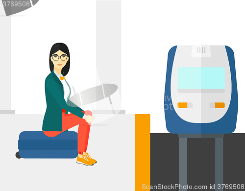 Image of Woman sitting on railway platform.