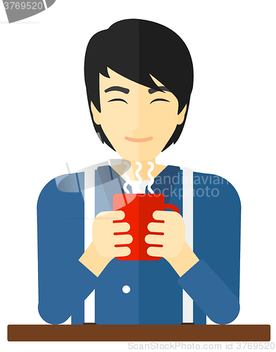 Image of Man sitting with cup of coffee.