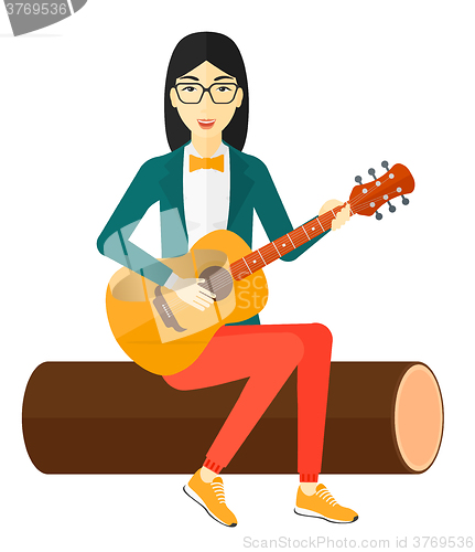 Image of Woman playing guitar.