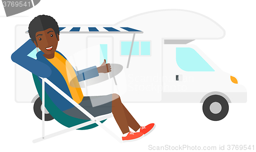 Image of Man sitting in front of motorhome.