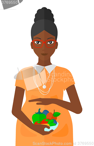 Image of Pregnant woman with vegetables.