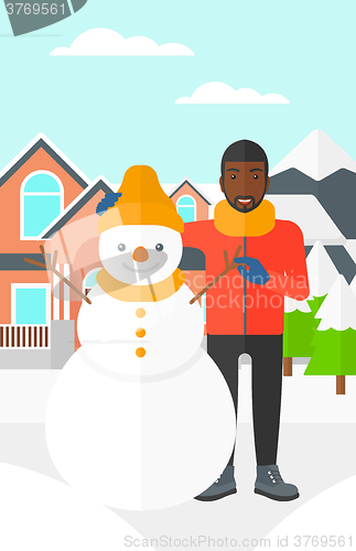 Image of Man posing near snowman.