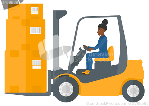 Image of Worker moving load by forklift truck.
