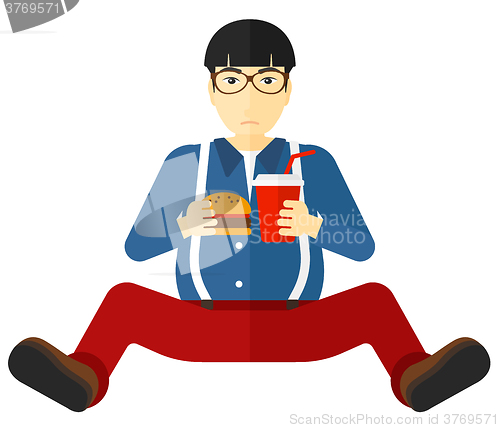 Image of Man eating hamburger. 