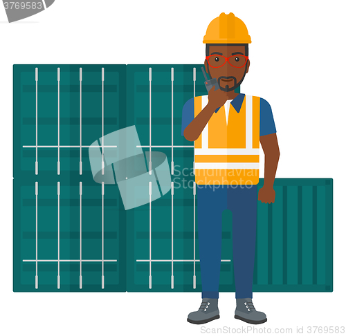 Image of Stevedore standing on cargo containers background.