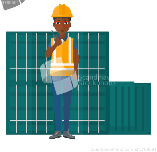 Image of Stevedore standing on cargo containers background.