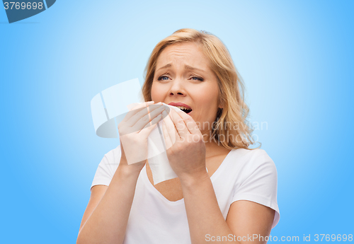 Image of unhappy woman with paper napkin sneezing