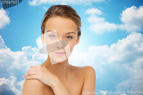 Image of smiling young woman over blue sky
