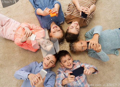 Image of happy smiling children lying on floor in circle