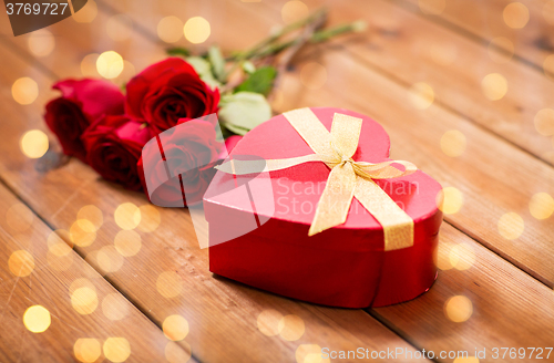 Image of close up of heart shaped gift box and red roses