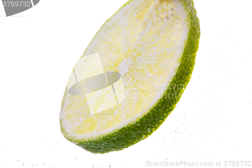 Image of lime slice falling or dipping in water 