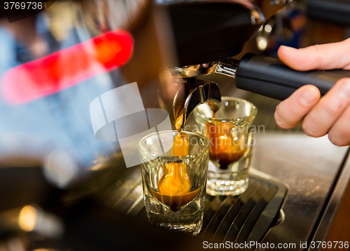 Image of close up of woman doing espresso by coffee machine