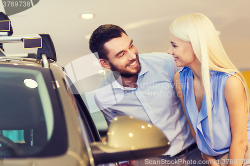 Image of happy couple buying car in auto show or salon