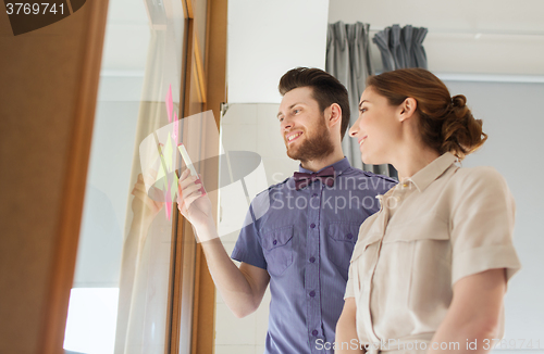 Image of creative team with stickers on glass at office