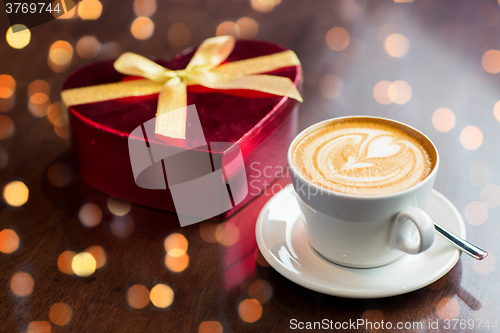 Image of close up of gift box and coffee cup on table