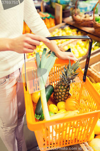 Image of close up of woman with food basket in market