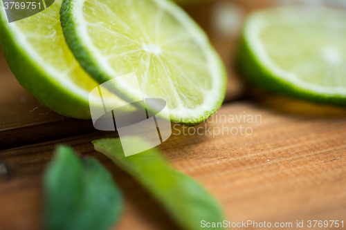 Image of lime slices on wooden table