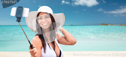 Image of smiling young woman taking selfie with smartphone