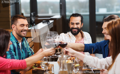 Image of friends dining and drinking wine at restaurant