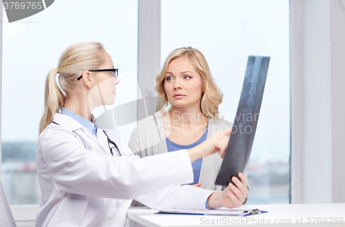 Image of woman patient and doctor with spine x-ray scan