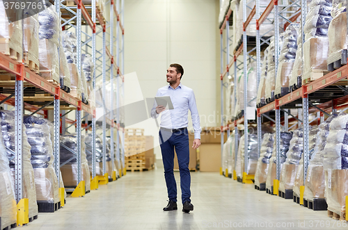 Image of happy businessman with tablet pc at warehouse