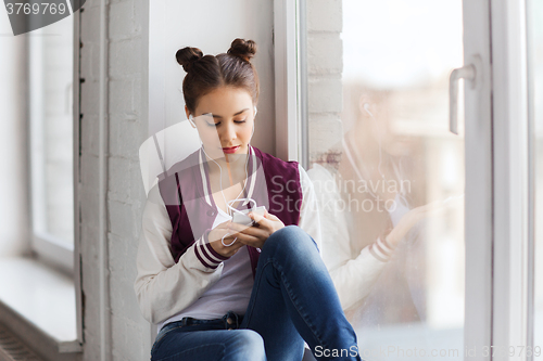 Image of teenage girl with smartphone and earphones