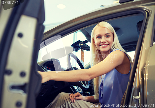 Image of happy woman inside car in auto show or salon