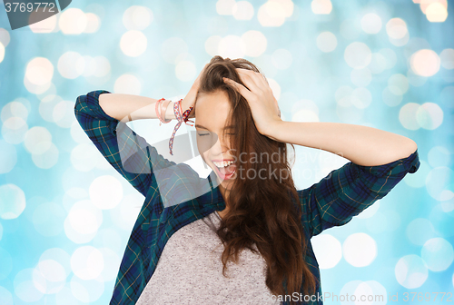 Image of happy pretty teenage girl holding to head