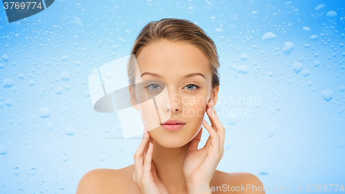 Image of young woman touching her face