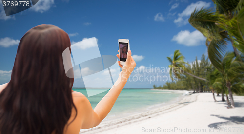 Image of young woman taking selfie with smartphone