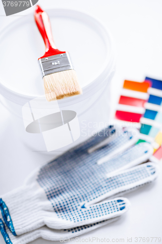 Image of paintbrush, paint pot, gloves and pantone samples